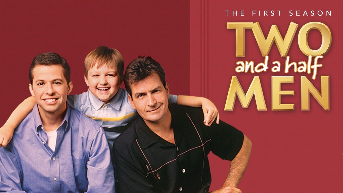 Elenco de Two and a Half Men na primeira temporada com Charlie Sheen, Jon Cryer e Angus T. Jones sentados no sofá.