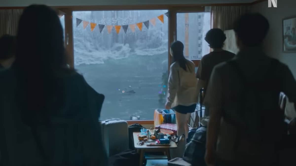 prioridade máxima para Google Images:Cena de A Grande Inundação (Netflix 2025) mostrando sobreviventes em apartamento olhando pela janela a inundação apocalíptica ao fundo, com decoração de festa e clima de tensão no ambiente interno.