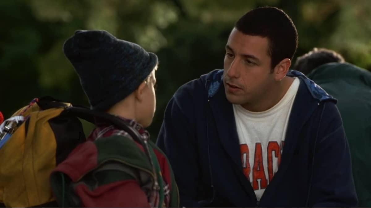 Cena de filme de comédia dramática com dois personagens conversando ao ar livre