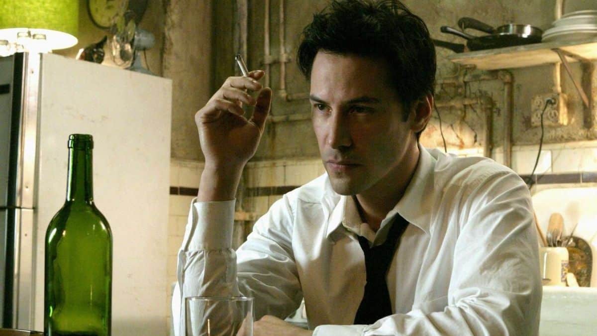 Keanu Reeves como John Constantine fumando cigarro em cena clássica do filme de 2005, representando o retorno do personagem em Constantine 2 previsto para 2026