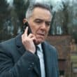 James Nesbitt ao telefone em cena tensa de Custe o Que Custar, nova série de suspense de Harlan Coben na Netflix, estreia 1º de janeiro de 2026