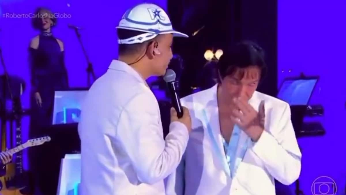 João Gomes (de costas com boné) ao lado de Roberto Carlos durante dueto no Especial de Natal Noite Feliz (Globo 2025), momento que gerou polêmica sobre desconforto ou emoção do Rei.