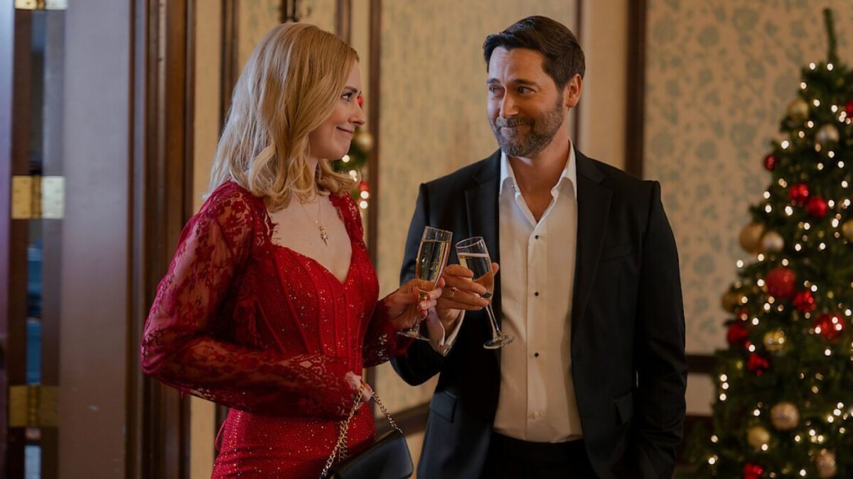 Elenco do filme Meu Pai Natal Secreto, Casal em cena romântica do filme O Meu Pai Natal Secreto com decoração de Natal ao fundo