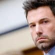 Ben Affleck em close com expressão séria durante entrevista e aparição pública