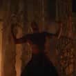 Homem em cena intensa dentro de um templo com fogo ao fundo em Extermínio: O Templo dos Ossos (2026)