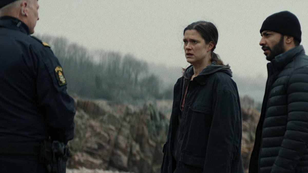 Elenco principal de Terra de Pecados (Krista Kosonen, Mohammed Nour Oklah e coadjuvante) em cena tensa ao ar livre com paisagem rural fria, série Nordic Noir da Netflix estreada em 2026