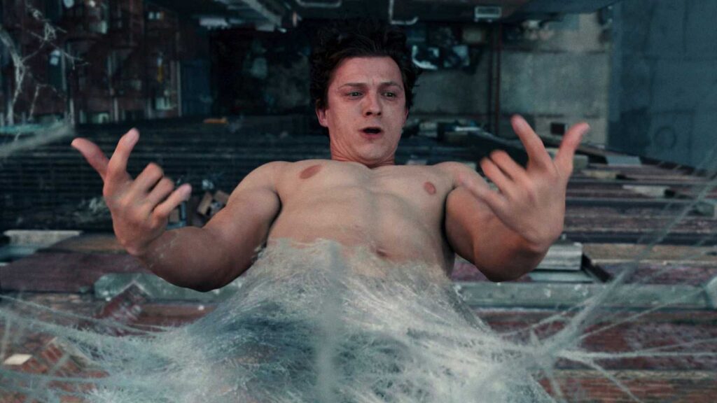 Tom Holland como Homem-Aranha em cena com teias, representando a transformação do personagem