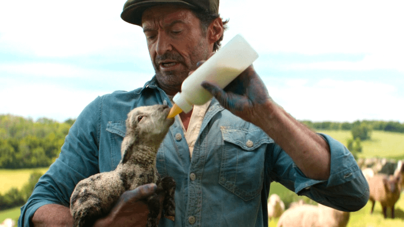 Hugh Jackman como pastor George com o cordeiro de inverno em cena de cuidado especial